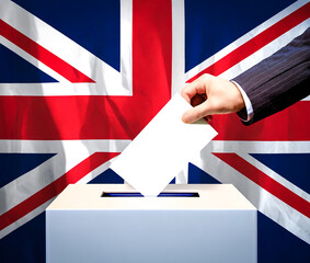 Hand placing a voting card in a UK Ballot Box during election year