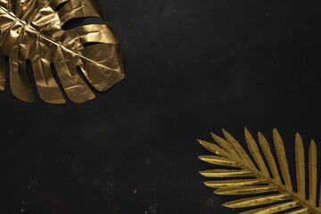 Creative layout with gold tropical palm leaves on black background. Minimal summer abstract pattern.