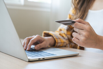 Internet banking, Online shopping at home, asian young woman hand in typing on keyboard, holding credit card, using laptop computer, spending money with purchase on store at home. Shopaholic ecommerce - obrazy, fototapety, plakaty
