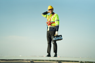 Specialist technician professional engineer checking top view of installing solar roof panel on the factory rooftop under sunlight. Engineers having service job of electrical renewable eco energy