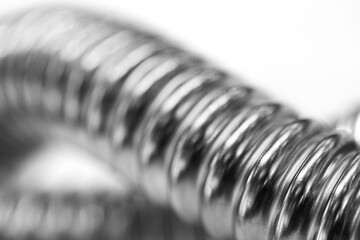 Stainless steel flexible corrugated hoses and flexi pipes, fittings and pressure joints close-up...
