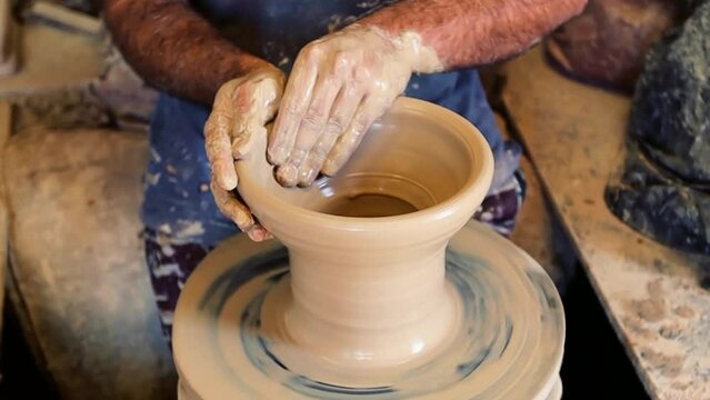 Man at pottery workshop. Unrecognized man producing pitcher from clay at pottery shop in Bahrain