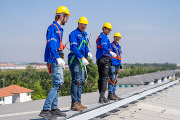 Specialist technician professional engineer checking top view of installing solar roof panel on the factory rooftop under sunlight. Engineers having service job of electrical renewable eco energy