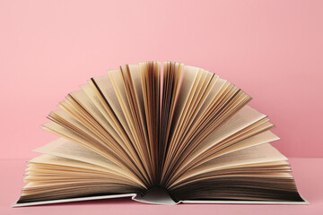 Open book on pink background. Space for text