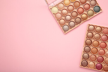 Pastel palette of eyeshadow on pink background. Space for text