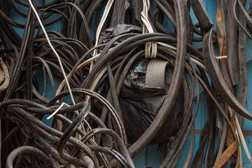 Various spare parts hang on the garage door: old wires, cords, bicycle tires