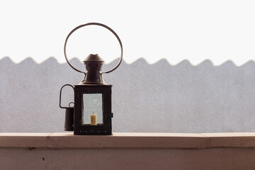 An old vintage lamp on the background of a white wall. Copy space.