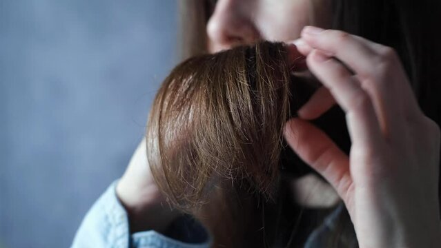 Close-up of the split and parched the hand of woman with brunette hair. Hair care concept