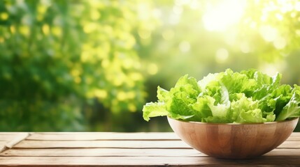  a wooden bowl filled with lettuce sitting on top of a wooden table in front of a blurry background of trees and a wooden table with a bowl of lettuce in the foreground.