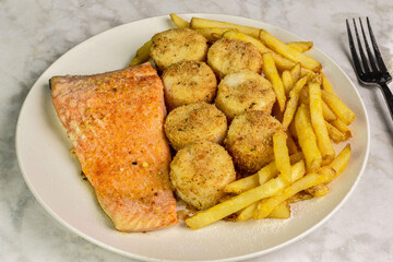 baked salmon with scallops served with a side of fries