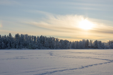 Very cold  January winter day scenery (-21ºC). Sun is shining just above horizon behind the...