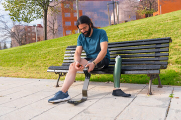 Physically disabled man adjusting prosthetic leg before running