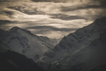 strong south wind in the alps at a cloudy and sunny winter day in the national park hohe tauern in austria