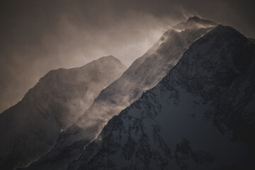 strong south wind in the alps at a cloudy and sunny winter day in the national park hohe tauern in...