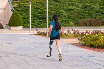 Runner with prosthetic leg running along a park