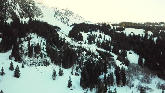 Sunset behind a mountin in the swiss alps with snow and a frozen lake