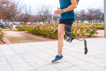 Disabled person with prosthetic leg running in an urban park