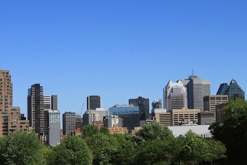 Montreal skyline in Downtown of the city, seen from Griffintown central neighborhood on a summer day. Skyscrapers and high-rise buildings in North America against blue sky.