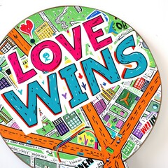 Bold graphic text sign stating "LOVE WINS"