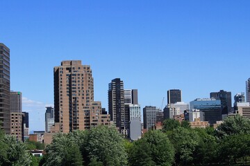 Montreal skyline in Downtown of the city, seen from Griffintown central neighborhood on a summer day. Skyscrapers and high-rise buildings in North America against blue sky.