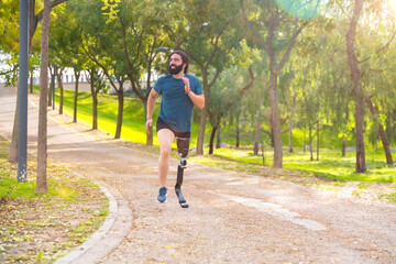 Sportsman with a artificial leg running along a path