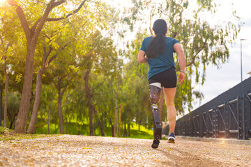 Sportsperson with prosthetic leg running along a park