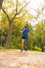 Vertical photo of a man with prosthetic leg running outdoors