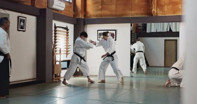 Students, karate or people learning martial arts in dojo for fitness, discipline or self defense combat. Demonstration, workout or kung fu master training athletes for fighting, education or class