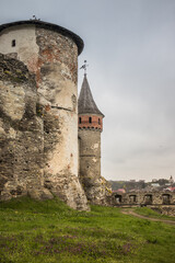 The part of Old Kamianets-Podilskyi Castle under a cloudy sky. Powerful bastions and towers of the...