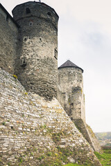 The part of Old Kamianets-Podilskyi Castle under a cloudy sky. Powerful bastions and towers of the...