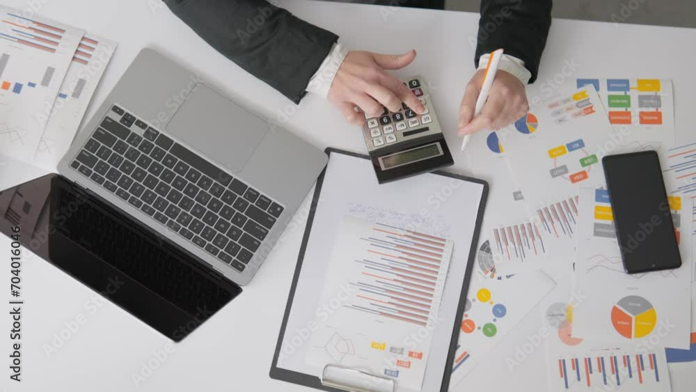 Aufkleber The accountant works intently on the preparation of annual financial statements using a calculator and a computer. A financial manager reviews reporting documents and schedules, developing strategies