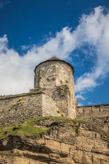 Old Kamianets-Podilskyi Castle under the blue sky. Part of the powerful bastions of the castle. The...