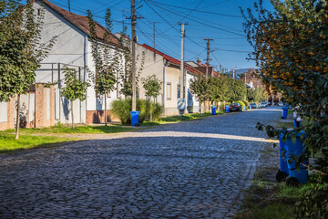 Blue garbage cans on the street in a small town near every house. Centralized garbage collection in a small cozy European city. Garbage collection on a certain day of the week.