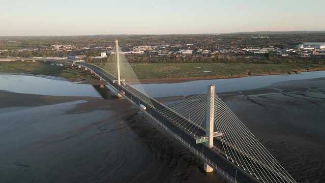 Aerial orbit view of The Mersey Gateway Bridge over the Mersey Estuary, Runcorn, Cheshire, England