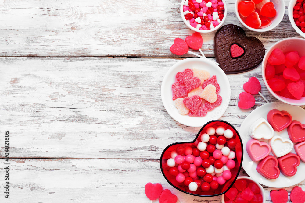 Aufkleber Valentines Day candy side border with a collection of sweets. Above view on a white wood background with copy space.