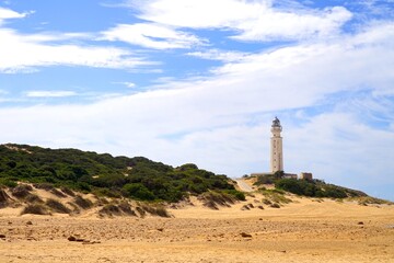 Fototapeta na wymiar Faro de Trafalgar, view over the dunes to the lighthouse at a sandy headland between Los Caños de Meca and Zahora, Vejer de la Frontera, Costa de la Luz, Andalusia, Spain