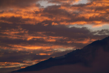 beautiful sunrise with orange sky in the mountains at a winter morning