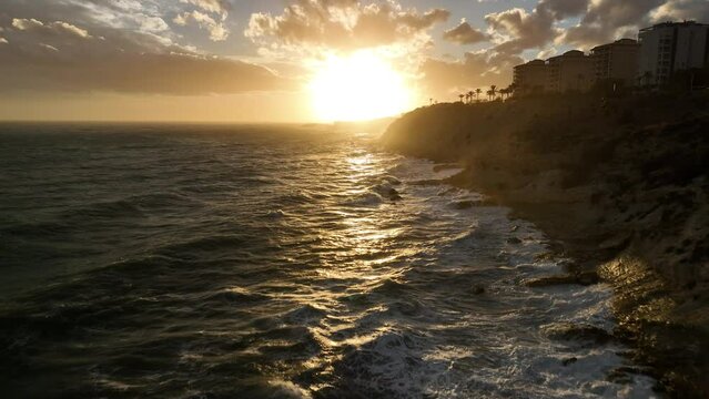 Atardecer con olas y el sol de fondo