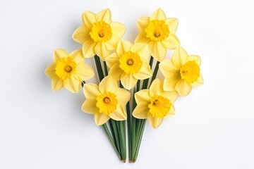  a bunch of yellow daffodils sitting on top of each other on top of a white table next to a vase with flowers on top of the table.