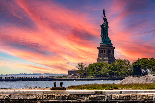 Wonderful sunrise view of the Statue of Liberty in New York (USA), from Ellis Island where the immigration museum of the Big Apple is located.