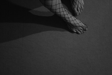 Women's legs in fishnet tights.