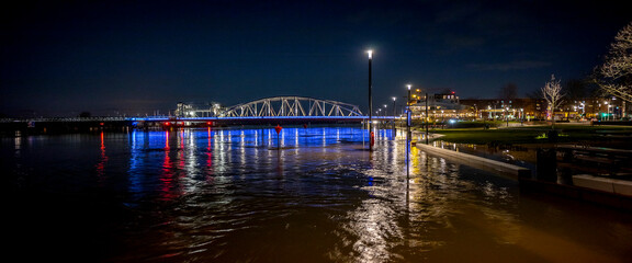 Colourful decoration on steel draw bridge in the background with high water levels of river IJssel...