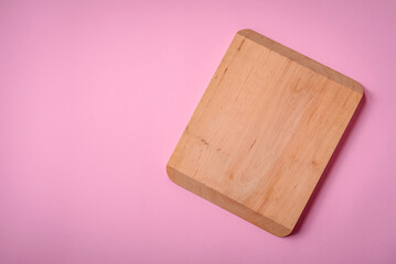 Empty wooden rectangular cutting board on a plain background, flatley with copy space