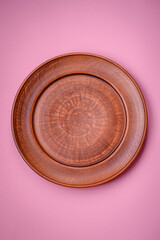 Empty round ceramic plate on a plain background, flatley with copy space