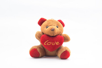 Osito de peluche abraza un corazón con la palabra Love escrita en el sentado en un plato de bombones para celebrar el día de San Valentín