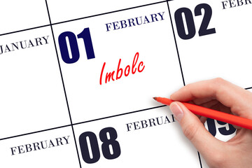 February 1. Hand writing text Imbolc on calendar date. Save the date.