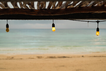 Vintage light bulb on the beach against the background of the sea and sky.
