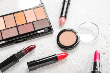 Set of cosmetic products with lipsticks on light background, closeup