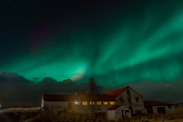 Northern Light,  spectacular Aurora borealis over a farm in Iceland