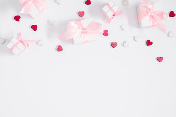 Valentine's Day composition. Gift with a bow and hearts on a white background. Wedding. Birthday. Happy Women's Day. Mothers Day. Flat lay, top view, copy space